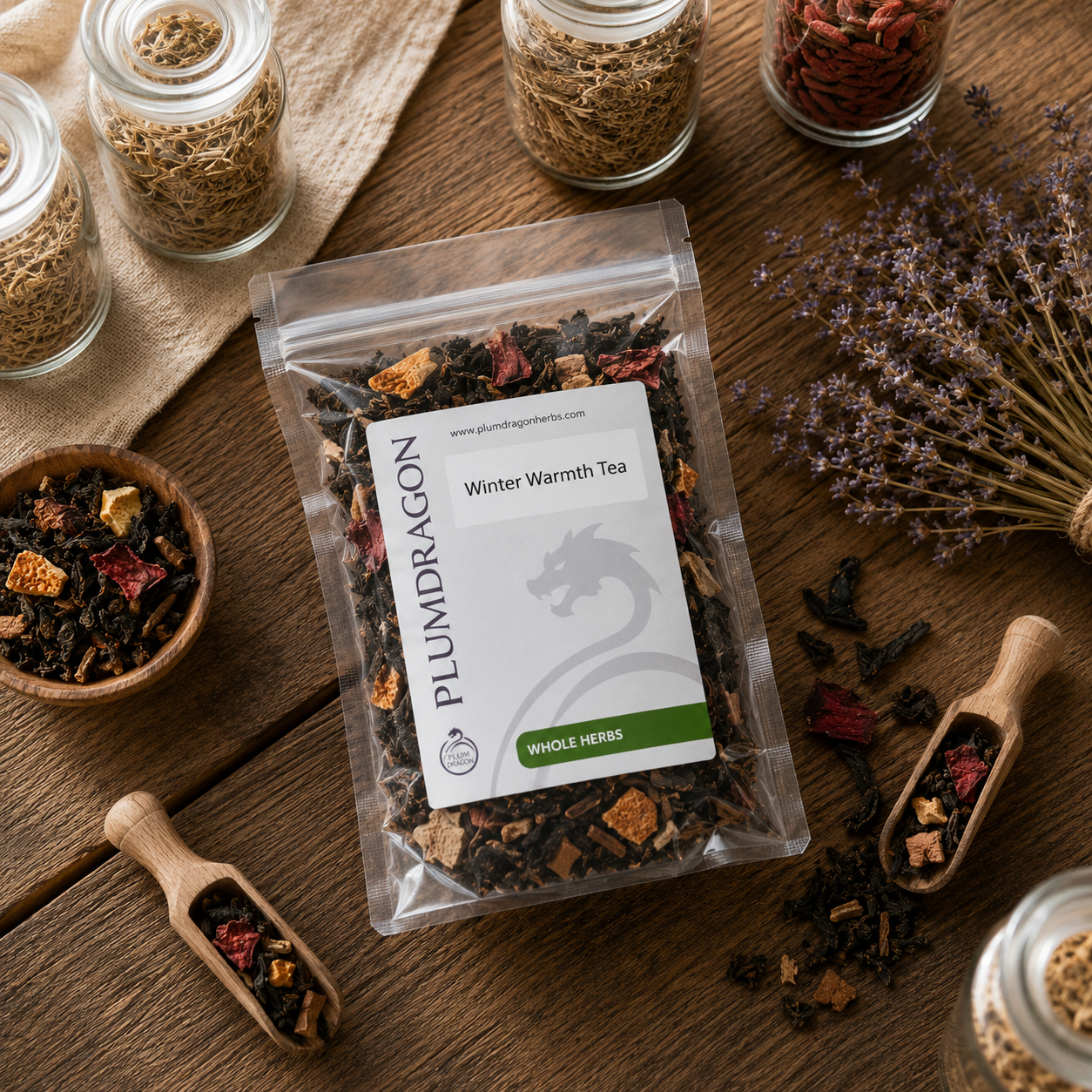 Plum Dragon Winter Warmth Tea package on a wooden surface with dried herbs and tea leaves.