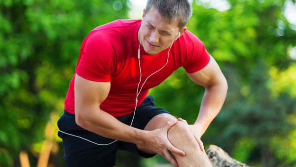 Male athlete with delayed onset muscles soreness, treating DOMS