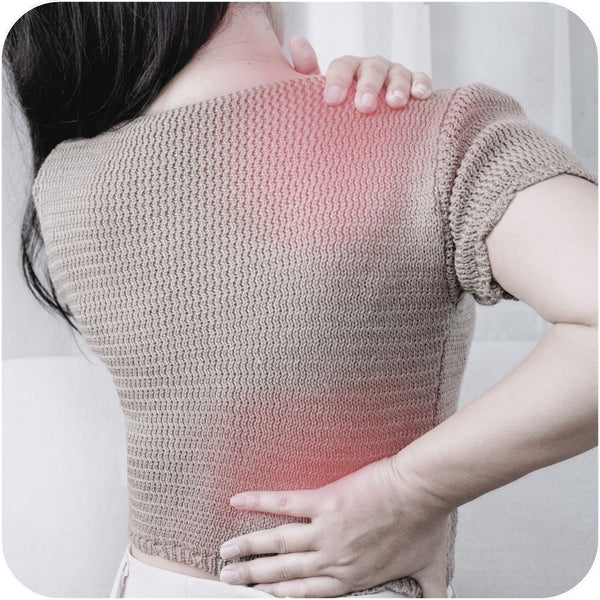 Woman stretching and in obvious pain from soft tissue injury where redness is shown on sweater