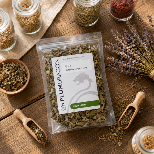 Packaged Ai Ye (Mugwort Leaf) with Plum Dragon branding on a wooden surface with dried plants and jars.