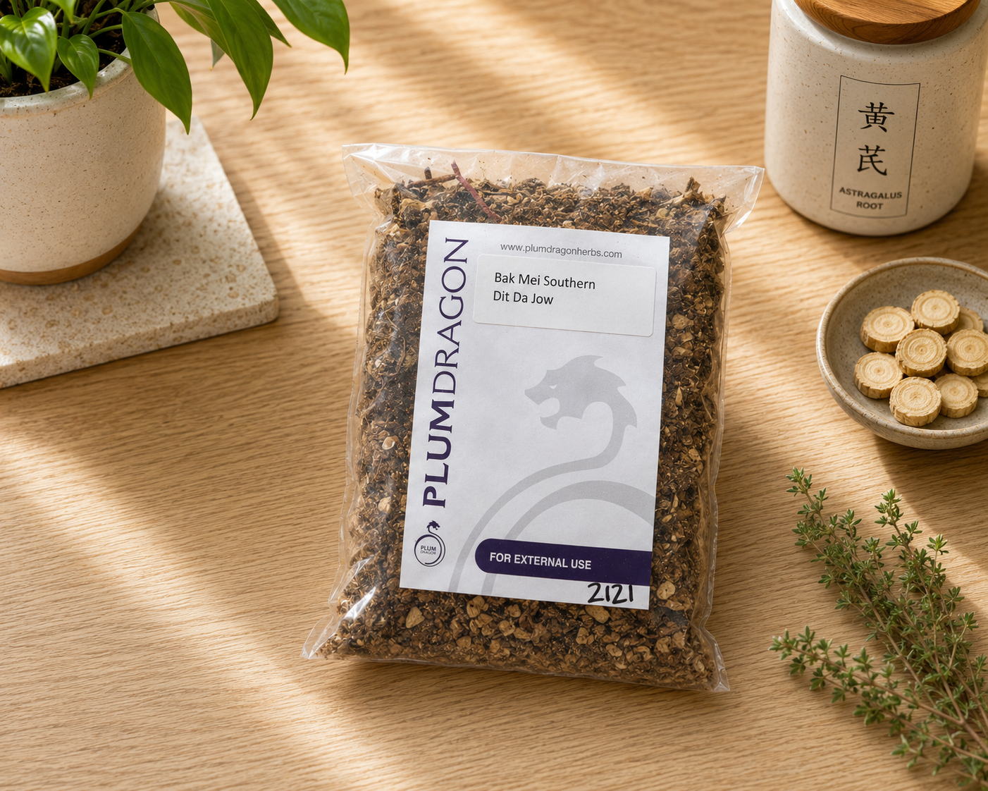 Bak Mei Southern Dit Da Jow Herbs in Plum Dragon Packaging on Apothecary counter