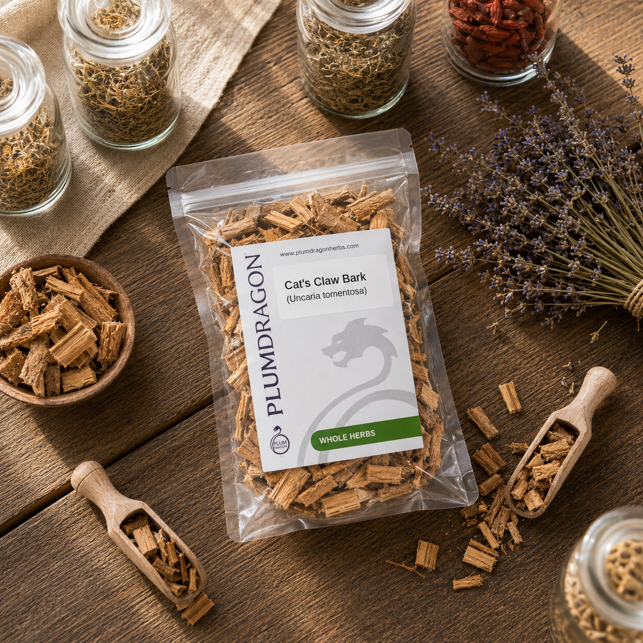 Packaged cat's claw bark with herbs and containers on a wooden surface, featuring the Plum Dragon brand.