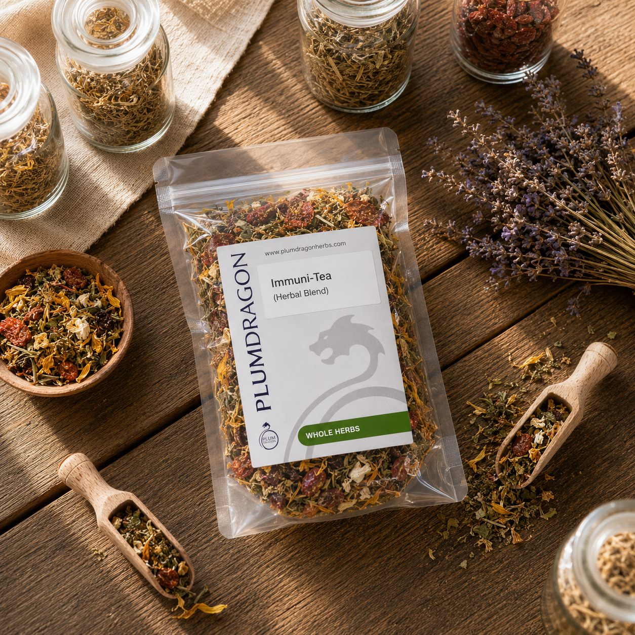 Plum Dragon Immuni-Tea packaging on a wooden surface with dried herbs and a scoop.