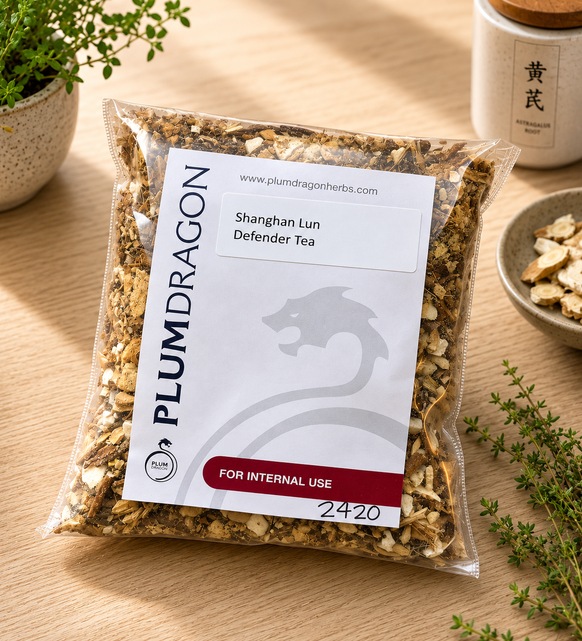 Shanghan Lun Defender Tea in Plum Dragon packaging on apothecary counter