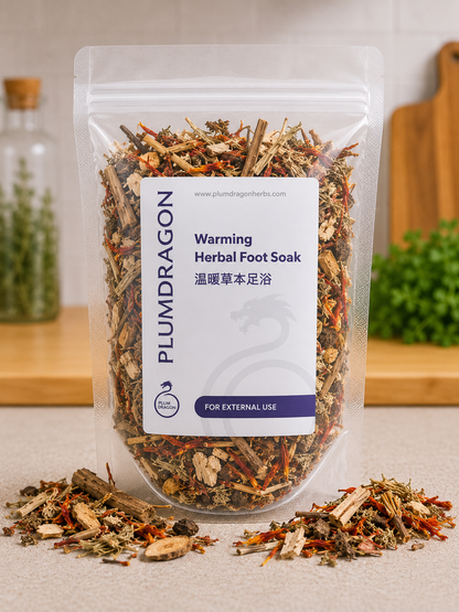 Plum Dragon warming herbal foot soak package with dried herbs on a neutral background