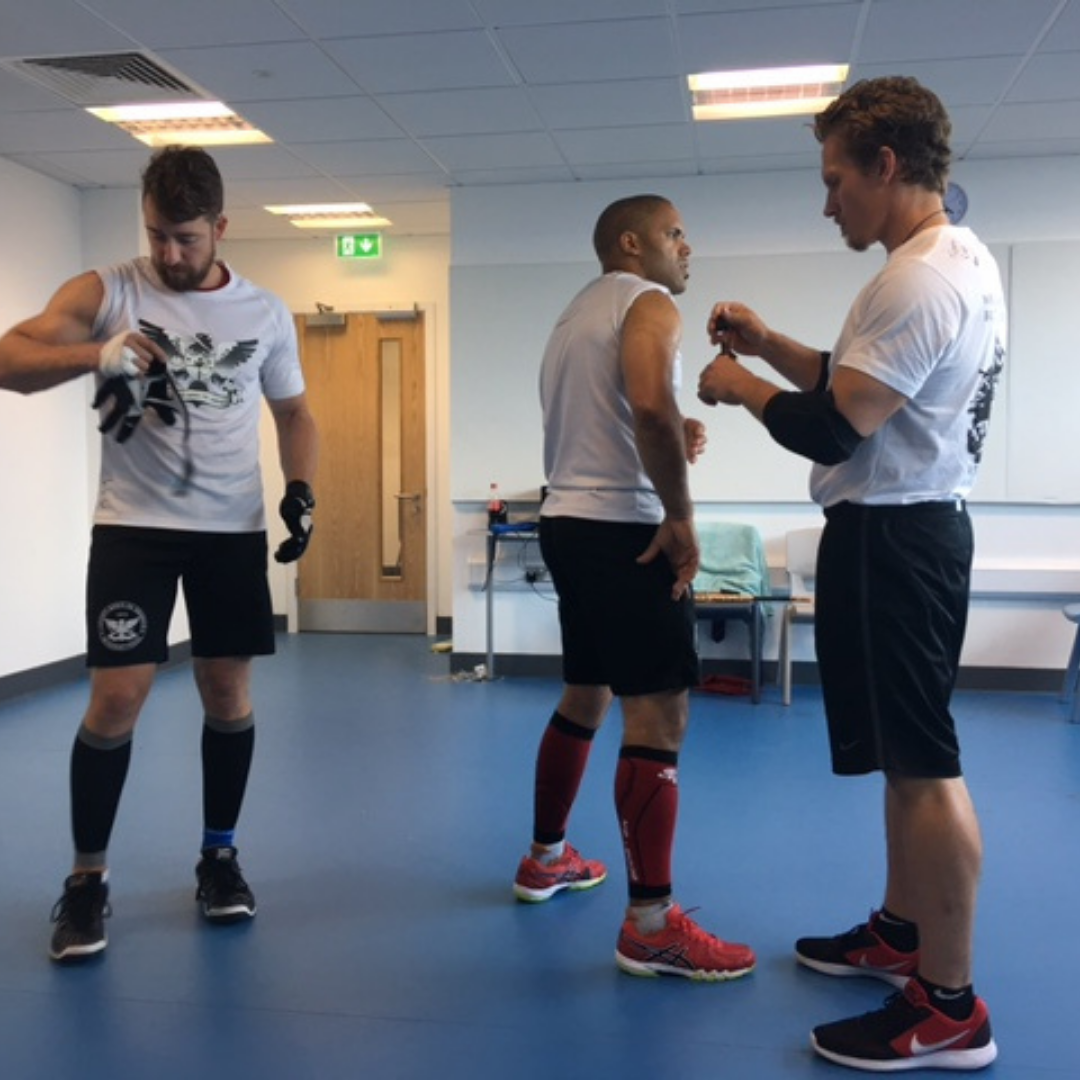 Image of world champion stick fighter Tom Voss using Ancestors Advanced on an elbow injury in martial arts training. 